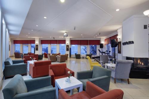 a lobby with couches and chairs and a fireplace at Palan Ski & Convention Resort Hotel in Erzurum