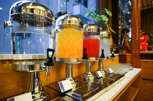 a display of drinks in glass jars on a counter at Muong Thanh Grand Saigon Centre Hotel in Ho Chi Minh City