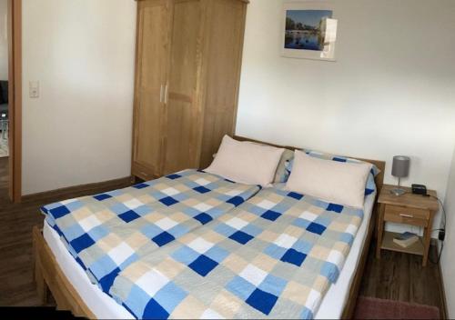 1 dormitorio con 1 cama con manta blanca y azul a cuadros en Ferienwohnungen Koch, en Marburg an der Lahn