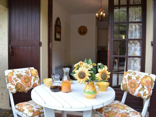 Appartement Le Lavandou, 1 pièce, 2 personnes - FR-1-251-66 في لو لا فاندو: طاولة بيضاء عليها زهور و مزهريات