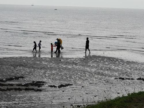 a group of people walking on the beach at Port Dickson PD Beach Front Homestay in Port Dickson
