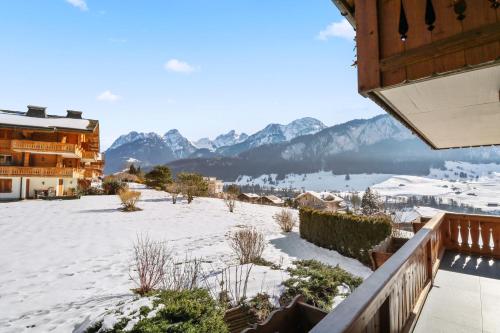 a view of a snow covered town with mountains at Logement spacieux et confortable in Chateau-d'Oex