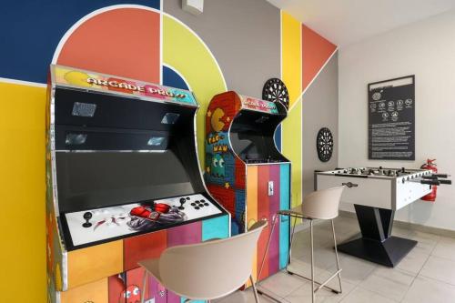 a colorful arcade room with a game machine and chairs at Subang Jaya SS15 6min to Bandar Sunway By Nexx Field in Subang Jaya