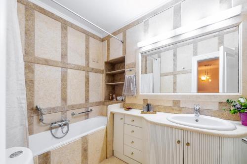 um banheiro com pia, banheira e espelho em RetroNuovo em Corfu Town