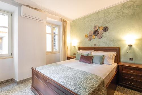 um quarto com uma cama e duas janelas em RetroNuovo em Corfu Town