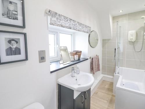 a white bathroom with a sink and a mirror at 5 Bryn Tirion in Blaenau-Ffestiniog
