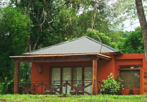 uma pequena casa laranja com um telhado de metal em La Mision Mocona - Lodge de Selva em Saltos del Moconá