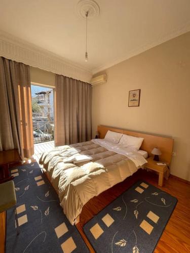 a bedroom with a bed and a large window at Tonia’s house in Leonidion