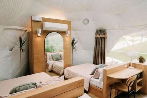 ダラギュテにある150 Peakway Mountain Resortのベッド2台、デスク、鏡が備わる客室です。