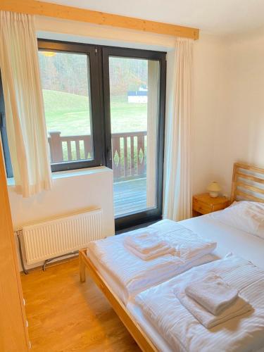 - une chambre avec un lit et une grande fenêtre dans l'établissement Apartment Steinwänd Top 7, à Grünau im Almtal