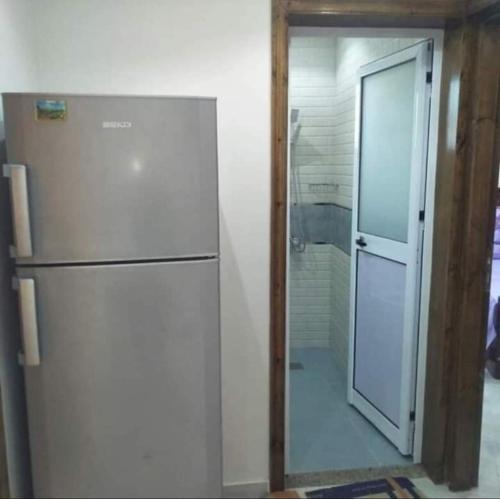 um frigorífico branco num quarto com uma porta de vidro em شاطئ المعموره em Alexandria