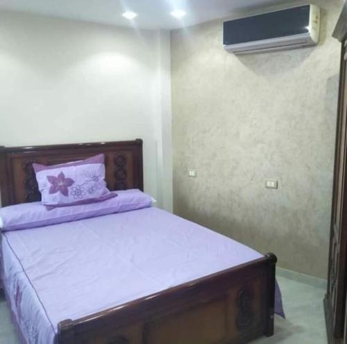 um quarto com uma cama com lençóis roxos e uma ventoinha em شاطئ المعموره em Alexandria