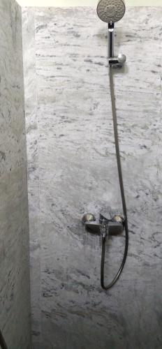 une douche avec un tuyau fixé à un mur dans l'établissement lalita homestay countryside, à Khajurâho
