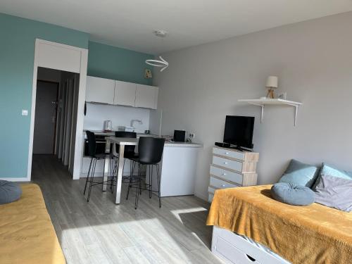 Cet appartement comprend une chambre avec un lit et une table ainsi qu'une cuisine. dans l'établissement Ocean View avec parking, à La Rochelle