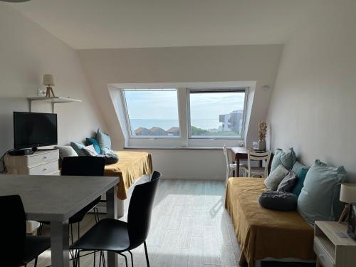 - un petit salon avec deux lits et une fenêtre dans l'établissement Ocean View Vue mer et Parking, à La Rochelle