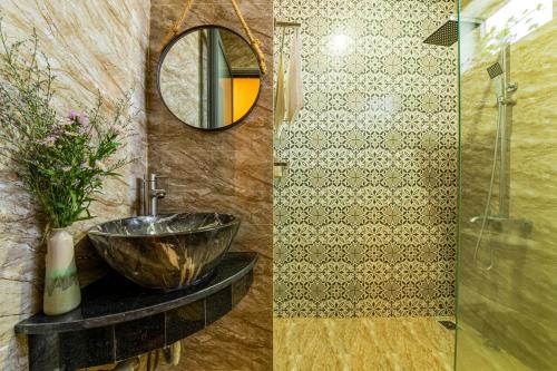 La salle de bains est pourvue d'un lavabo et d'un miroir. dans l'établissement Hoi An Paddy House Homestay, à Hội An