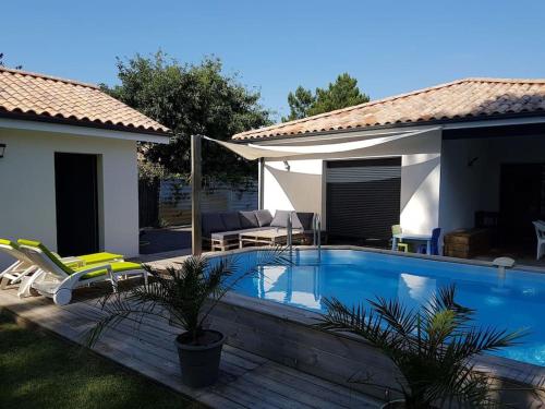 - une piscine dans une cour avec une maison dans l'établissement Guest house privative pour 2 sur Lege cap Ferret, à Lège