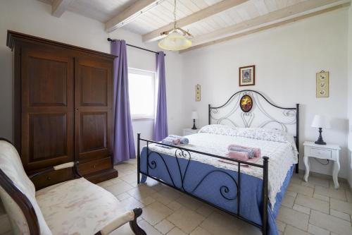 Un dormitorio con una cama y una silla y una ventana. en Casina delle Rose - Levante, en Polignano a Mare