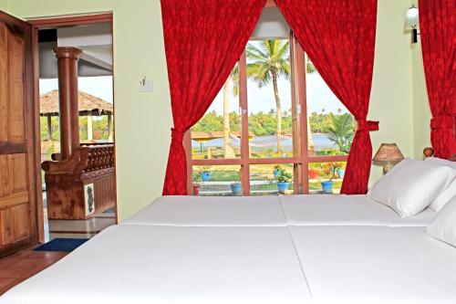 a bedroom with a bed and a window at Breeze Backwater Homes in Cochin