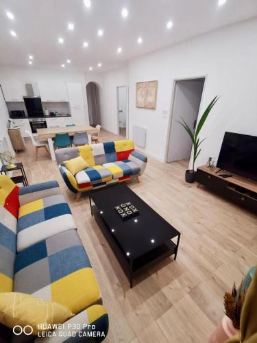 a living room with a couch and a table at Appartement 75 m2 au cœur du Sud Ouest in Villeneuve-sur-Lot
