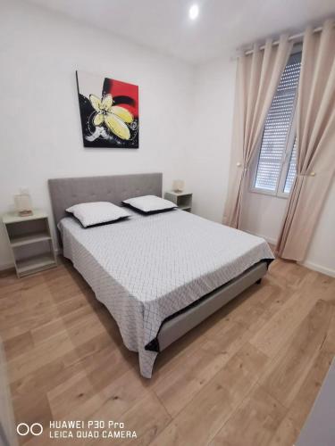 a bedroom with a bed with a butterfly picture on the wall at Appartement 75 m2 au cœur du Sud Ouest in Villeneuve-sur-Lot