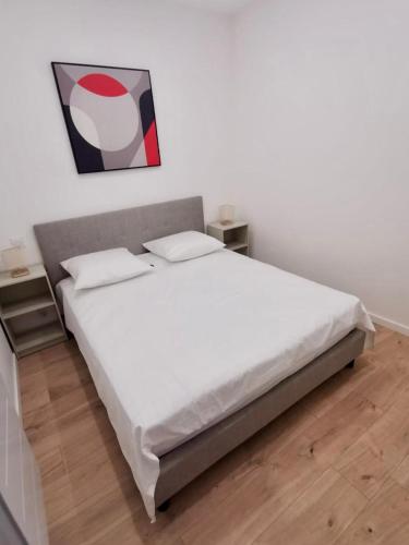 a bedroom with a large bed with white sheets at Appartement 75 m2 au cœur du Sud Ouest in Villeneuve-sur-Lot