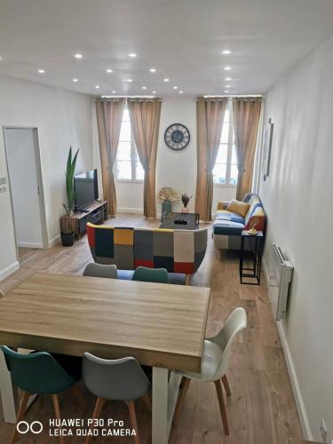 a living room with a table and a couch at Appartement 75 m2 au cœur du Sud Ouest in Villeneuve-sur-Lot