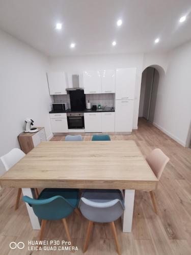 une salle à manger avec une table et des chaises en bois dans l'établissement Appartement 75 m2 au cœur du Sud Ouest, à Villeneuve-sur-Lot