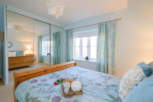 um quarto com uma cama com uma colcha azul em The Quarter Deck em Aldeburgh