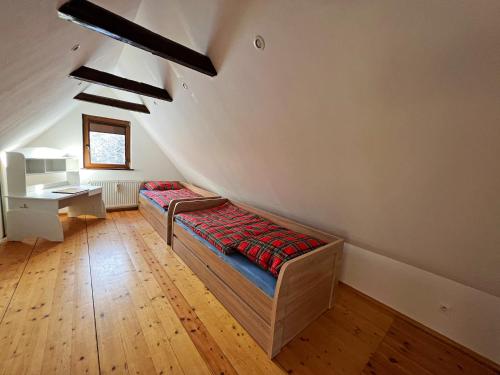 a attic room with two beds and a desk at Chatka Baby Jagi in Ściegny