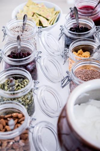 a table topped with jars filled with different types of food at Sandkaas Badehotel in Allinge