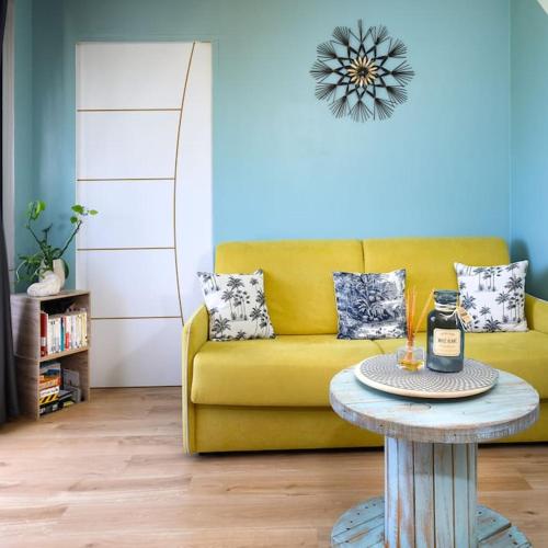 - un salon avec un canapé jaune et une table dans l'établissement Livianna, appartement 2 personnes avec une magnifique vue mer à Saint-Denis, à Saint-Denis