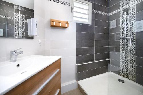 uma casa de banho com um lavatório e um chuveiro em Livianna, appartement 2 personnes avec une magnifique vue mer à Saint-Denis em Saint-Denis
