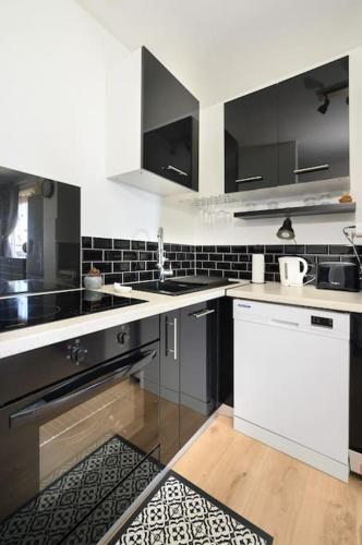 uma cozinha com electrodomésticos a preto e branco e um balcão em Livianna, appartement 2 personnes avec une magnifique vue mer à Saint-Denis em Saint-Denis