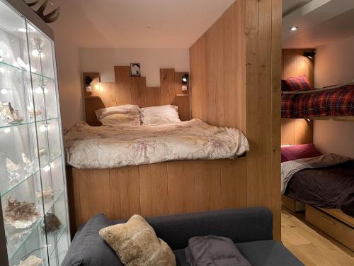 1 dormitorio con 1 cama en una pared de madera en Cozy studio au centre du village & superbe vue en Les Contamines-Montjoie