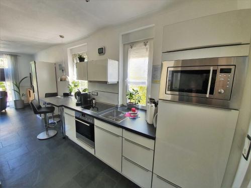 eine Küche mit Spüle und Mikrowelle in der Unterkunft Küstenvilla Usedom in Zinnowitz