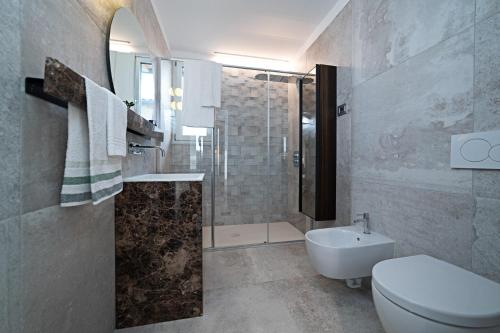 La salle de bains est pourvue d'une douche, de toilettes et d'un lavabo. dans l'établissement APARTMENT YIN & YANG - Regarda Travel, à Lazise