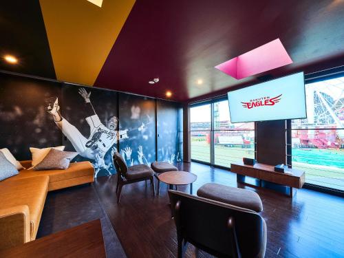 uma sala de estar com uma televisão e um ecrã grande em Rakuten STAY x EAGLES 102 with terrace em Sendai