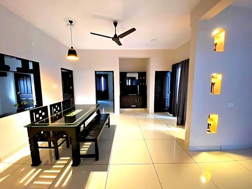 a dining room with a table and a ceiling fan at Urbane Cove in Trivandrum