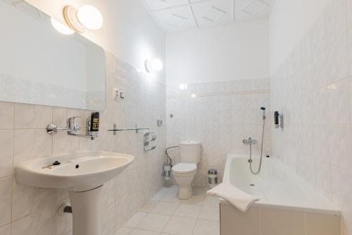 a white bathroom with a sink and a toilet at Hotel Amadeus in České Budějovice