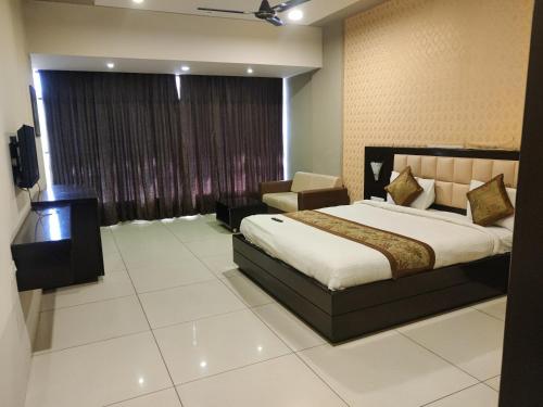 a bedroom with a bed and a chair in a room at HOTEL RESTANDVIEW in Anand