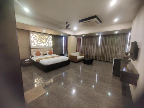 a bedroom with a bed and a couch and a tv at HOTEL RESTANDVIEW in Anand
