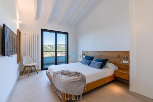 ein Schlafzimmer mit einem Bett und einem großen Fenster in der Unterkunft M4r 02 Can Parra Port de Andratx in Andratx
