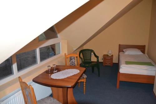 a room with a bed and a table and a bed at Hotelik Orlik in Legnickie Pole
