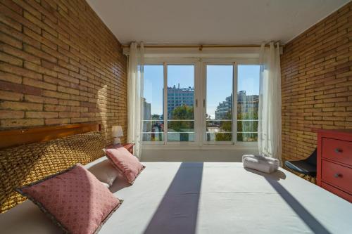 a bedroom with a brick wall and a bed with pillows at HomeHolidaysRentals Miracel - Costa Barcelona in Malgrat de Mar