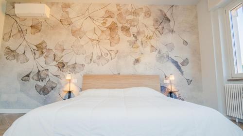 1 dormitorio con cama y pared de flores en The Roman Villa View - Italian Homing, en Desenzano del Garda