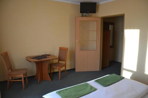 a bedroom with a bed and a table and chairs at Hotelik Orlik in Legnickie Pole