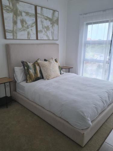 a large white bed in a room with a window at Ballito 134 in Ballito