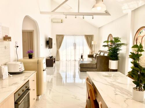 a kitchen and living room with white walls and ceilings at Zenzen Pool Villa in Chiang Mai