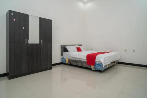 1 dormitorio con 1 cama y armario grande en RedDoorz Syariah Near Syamsudin Noor Airport 4, en Ulin